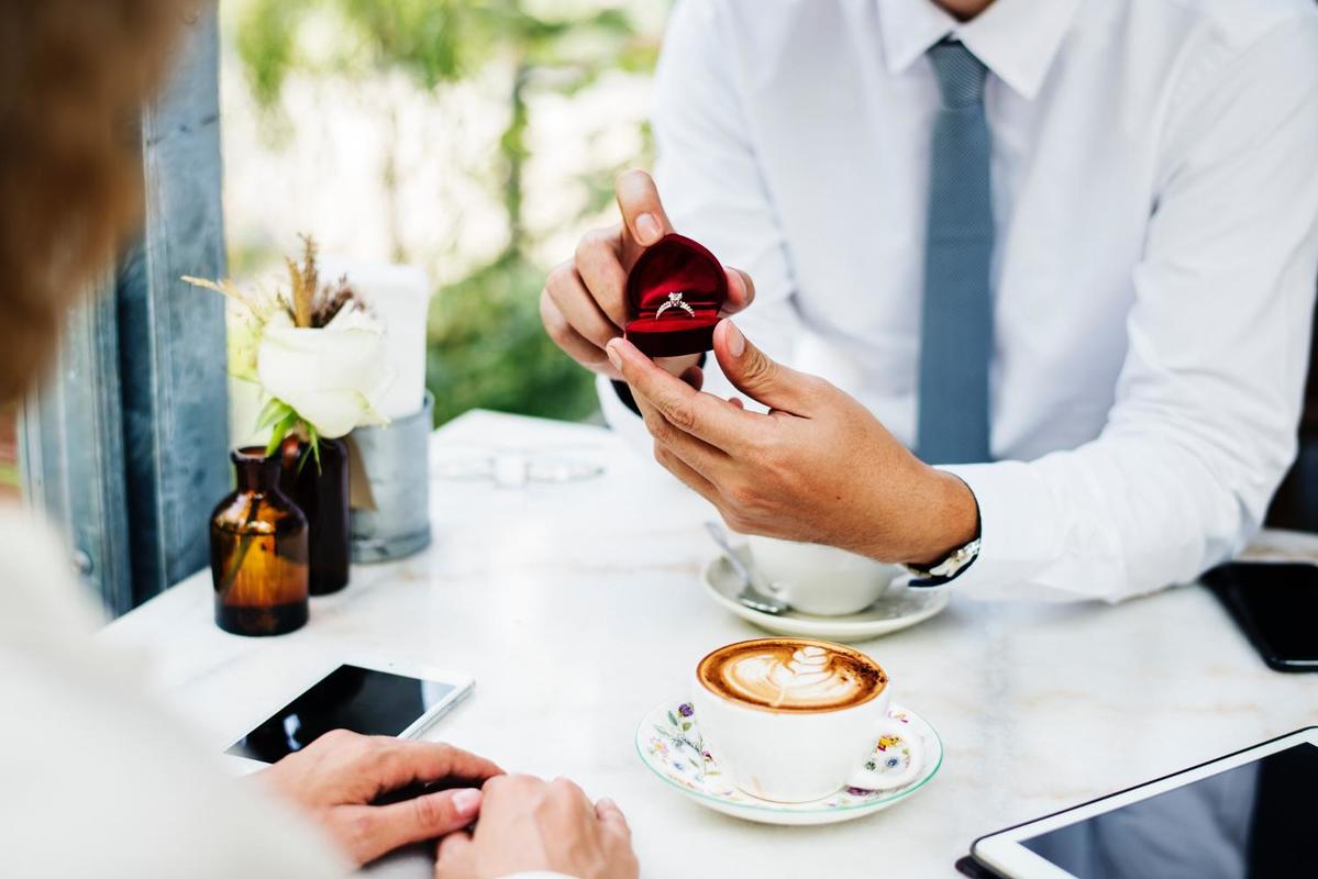 Photographie d'un marié qui fait sa demande en mariage au restaurant