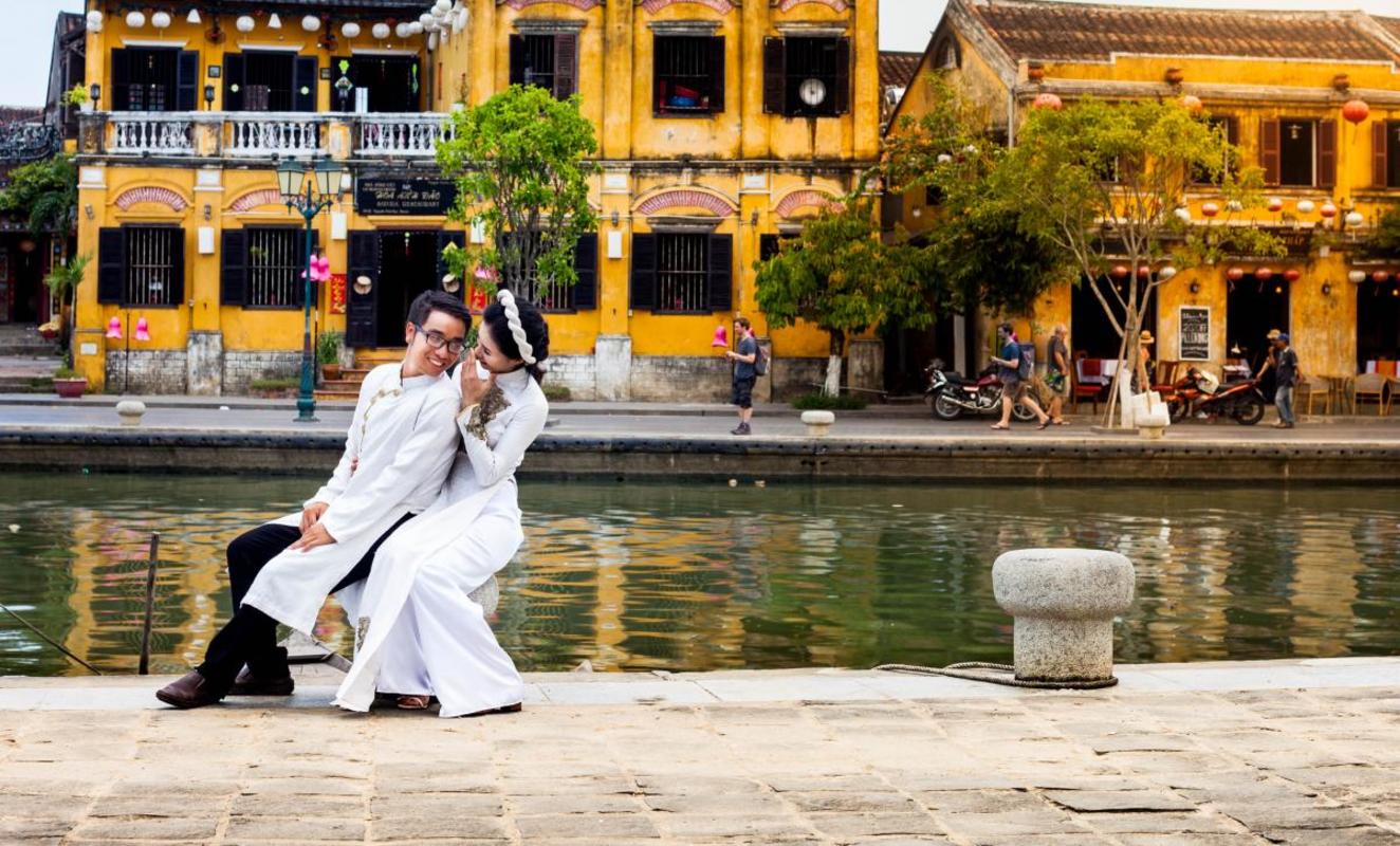 Photographie d'un couple d'amoureux assis près d'un port au Vietnam