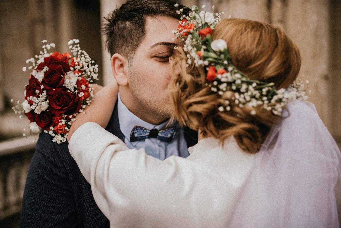 Mariage en Normandie - photographie d'un couple de mariés qui s'embrasse à la sortie de la cérémonie