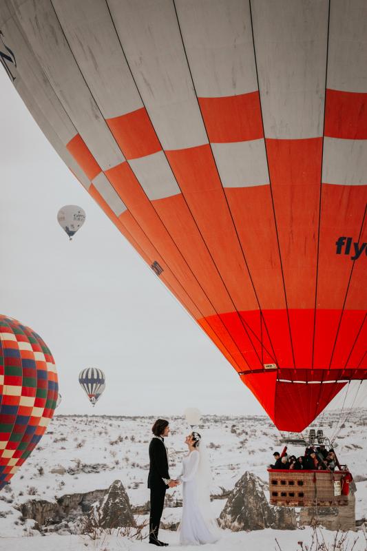 Mariage en Normandie - photographie d'un couple se mariant dans la neige au pied de montgolfières