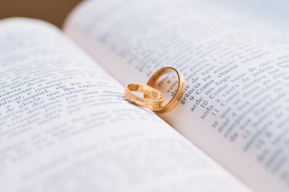 Mariage en Normandie - photographie de deux alliances au milieu d'un livre ouvert