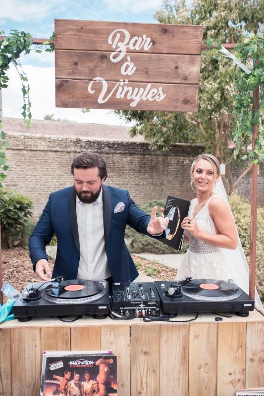 Mariage en Normandie - photo d'un couple de mariés jouant au dj grâce au bar à vinyles