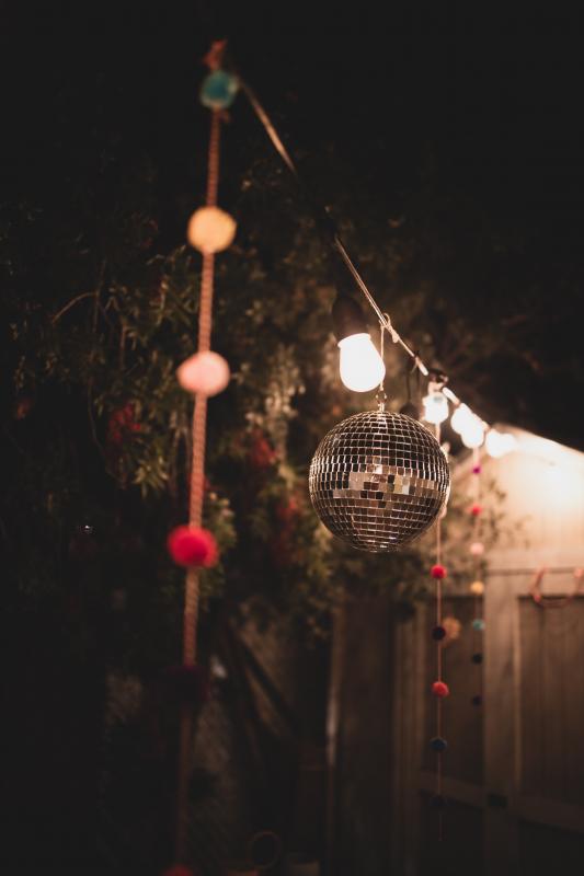 Mariage en Normandie - photographie d'une décoration de mariage avec une guirlande et une boule a facettes pour une ambiance hippie chic