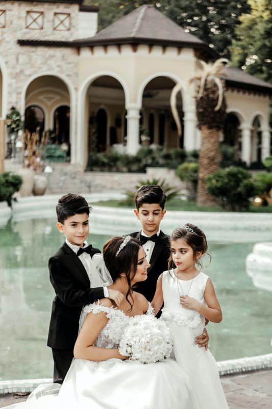 Mariage en Normandie - photo d'une mariée entourée de 3 enfants dans le parc d'un domaine 