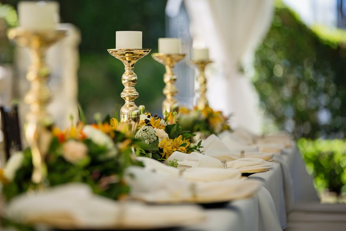 Mariage en Normandie - photo d'une table de mariage dans le thème baroque avec des chandeliers dorés et des grosses fleurs en centre de table